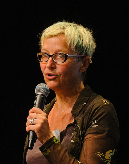 Portrait von Barbara Fricke mit Mikrofon in der Hand