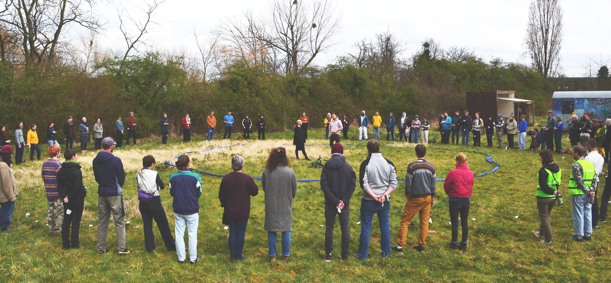 Teilnehmende der Wasserkonferenz bilden einen Abschlusskreis auf der Wiese