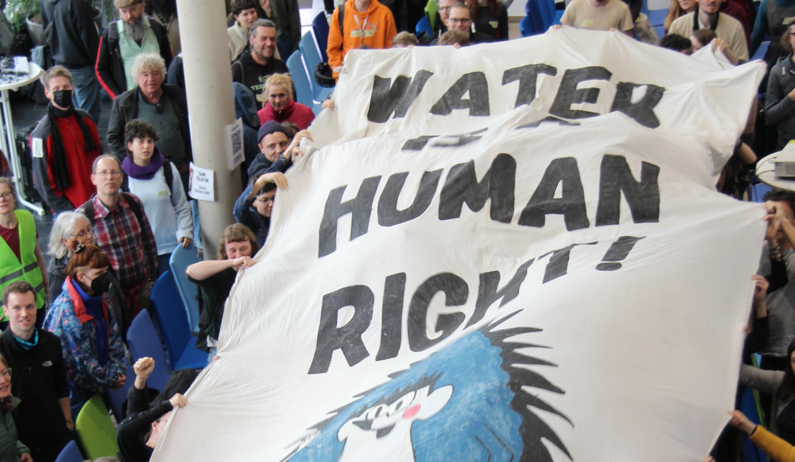Menschen tragen ein Banner mit der Aufschrift Water is a Human RIght